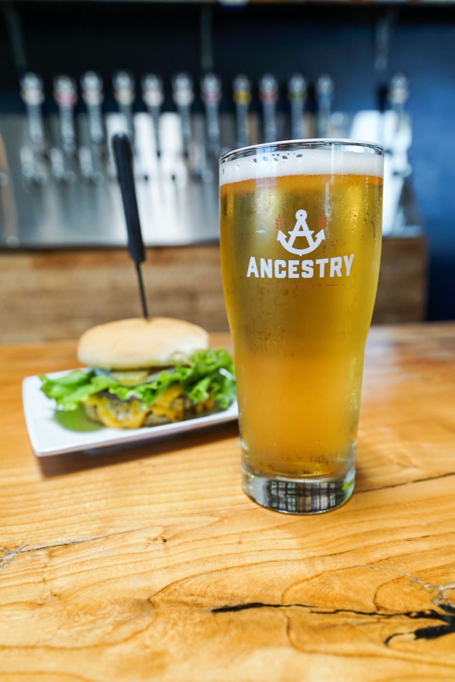 A pint of Light Wave next to a Happy Hour Double burger